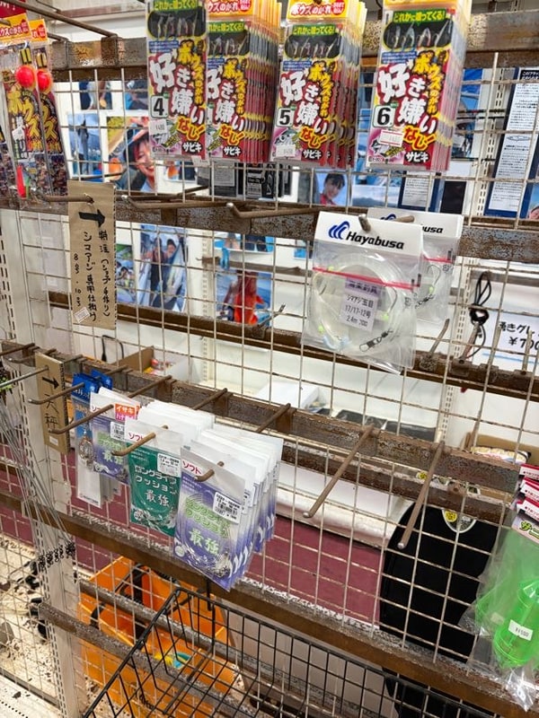 釣具屋の棚に、サビキ仕掛けの袋がずらりと吊り下がっている。袋には大きく「ボウズのがれ 好き嫌いなし サビキ」と鈎の号数が印刷されている。