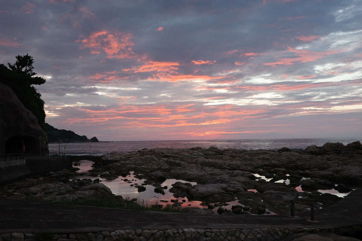 能登の岩礁海岸の夕焼け、潮だまりに残光